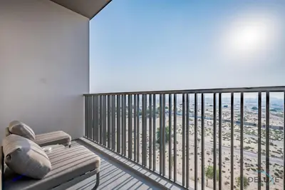 a balcony with a bench and a view of the beach at Appealing Studio in MAG EYE 890, Mohammad Bin Rashid City by Deluxe Holiday Homes in Dubai
