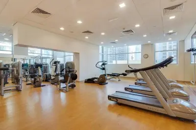 a gym with several treadmills and cardio machines at Luxury loft apartment downtown in Dubai