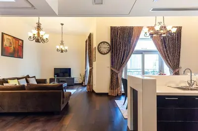 a kitchen and living room with a couch and a clock at Luxury loft apartment downtown in Dubai