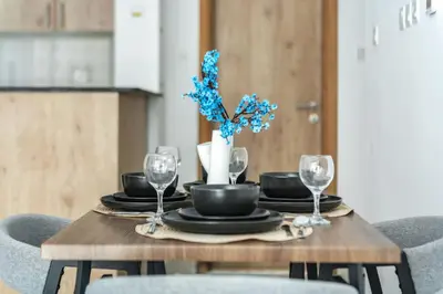 a dining room table with glasses and blue flowers on it at ShoresInn - Radiant 1BR in Dubai Marina in Dubai