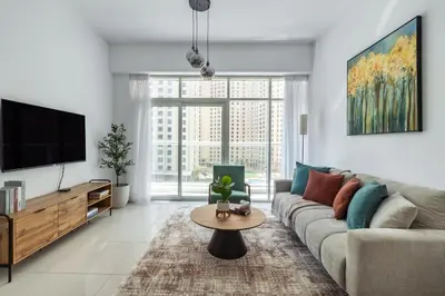 a living room with a couch and a tv at ShoresInn - Radiant 1BR in Dubai Marina in Dubai