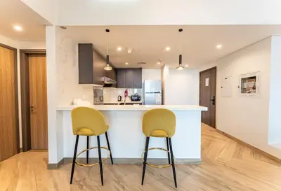 a kitchen with two bar stools and a counter top at Dubai Luxe Haven - World Record Residence in Dubai