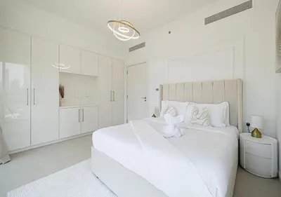 a white bedroom with a white bed with a teddy bear on it at Stylish Burj khalifa view 5 Star 4BD Apartment in Downtown with Dubai Mall access - Brand New Apartment in Dubai