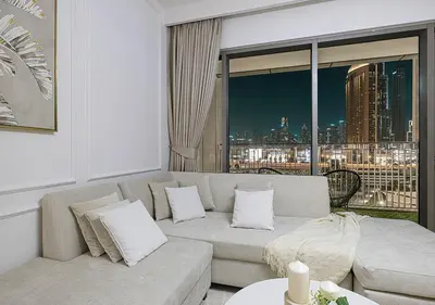 a living room with a couch and a large window at Stylish Burj khalifa view 5 Star 4BD Apartment in Downtown with Dubai Mall access - Brand New Apartment in Dubai