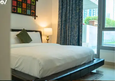 a bedroom with a bed with a window and a lamp at Luxury 2BR Suite I Garden View I Downtown Dubai in Dubai
