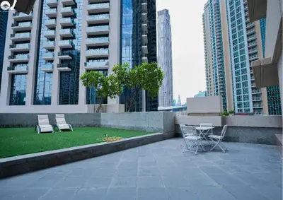 two chairs and a table on a rooftop with buildings at Luxury 2BR Suite I Garden View I Downtown Dubai in Dubai
