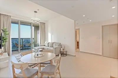 a living room with a table and chairs and a couch at Luxury Stay at Forte Emaar - 5 Min Walk to Burj in Dubai
