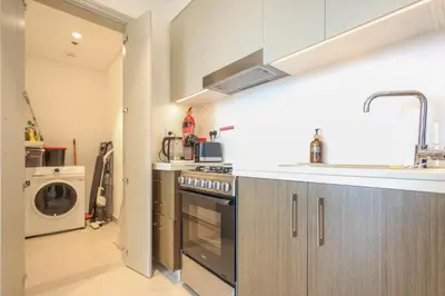 a kitchen with a stove and a washer and dryer at Luxury Stay at Forte Emaar - 5 Min Walk to Burj in Dubai