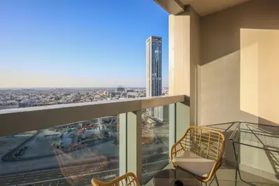 a balcony with two chairs and a view of a city at Luxury Stay at Forte Emaar - 5 Min Walk to Burj in Dubai