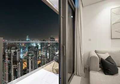 a room with a view of a city at night at High Floor Apartment in 5 Star Hotel with Infinity Pool Burj View Gym Spa Sauna in Dubai