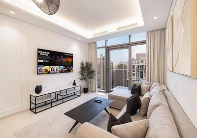a living room with a couch and a tv at High Floor Apartment in 5 Star Hotel with Infinity Pool Burj View Gym Spa Sauna in Dubai