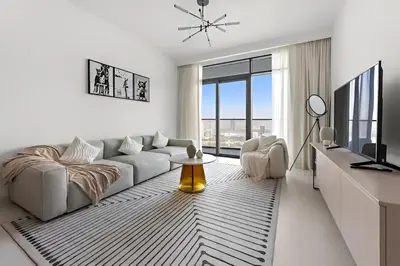 a white living room with a couch and a table at 2BR Beachfront Apt with Stunning Dubai Marina View in Dubai