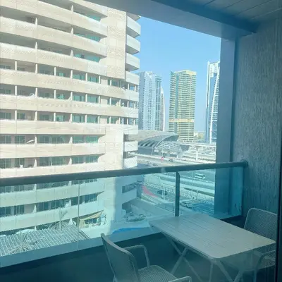 a balcony with a table and chairs in a building at Skyline Studio Apartment with Balcony in Dubai Marina in Dubai
