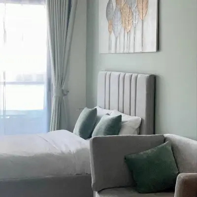a bedroom with a bed and a couch and a window at Skyline Studio Apartment with Balcony in Dubai Marina in Dubai