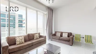 a living room with two couches and a large window at Modern & Spacious 2BR Apartment in Dubai