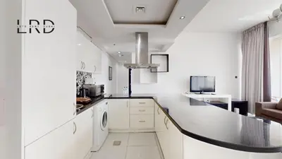a white kitchen with a washer and dryer at Modern & Spacious 2BR Apartment in Dubai
