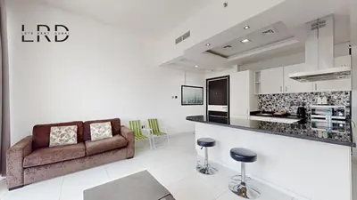 a living room with a couch and a kitchen at Modern & Spacious 2BR Apartment in Dubai