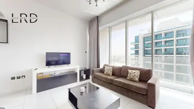 a living room with a couch and a tv at Modern & Spacious 2BR Apartment in Dubai