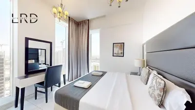 a hotel room with a bed and a desk at Modern & Spacious 2BR Apartment in Dubai