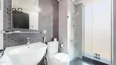 a bathroom with a white toilet and a sink at Modern & Spacious 2BR Apartment in Dubai