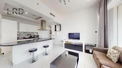 a kitchen and living room with a couch and a counter at Modern & Spacious 2BR Apartment in Dubai