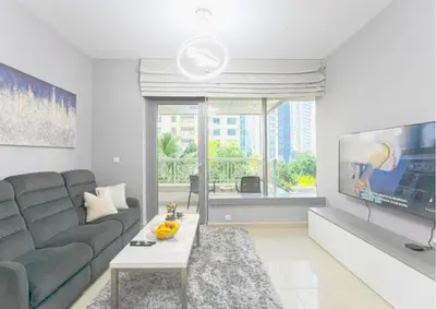 a living room with a couch and a tv at Stylish 2BR I Partial Burj View I Downtown Dubai in Dubai