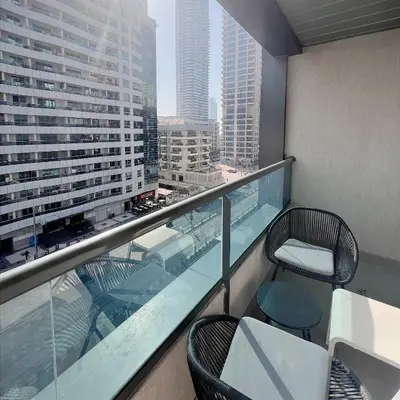 a balcony with two chairs and a table on a building at Studio Apartment with Stunning Marina Views in Dubai
