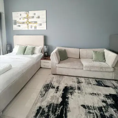 a living room with a white couch and a rug at Studio Apartment with Stunning Marina Views in Dubai