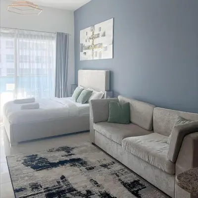 a living room with a couch and a bed at Studio Apartment with Stunning Marina Views in Dubai