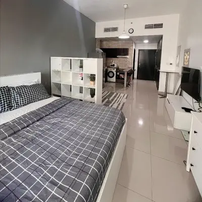 a bedroom with a large bed and a kitchen at Studio with Sunset Views at Dubai Marina in Dubai