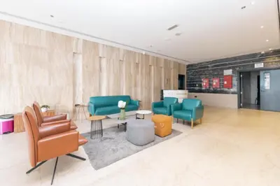 a waiting area with chairs and tables in a lobby at Studio with Sunset Views at Dubai Marina in Dubai