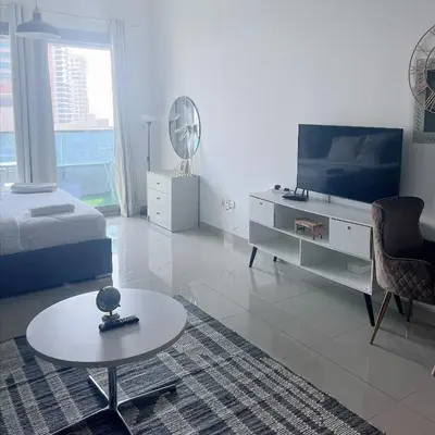a living room with a bed and a table and a bed and a tv at Studio with Marina Breeze in Dubai