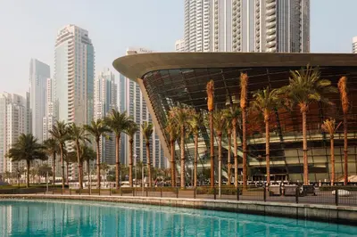 a pool with palm trees in front of a city at Sophisticated Studio near Burj Khalifa in Dubai