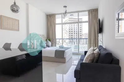 a living room with a bed and a couch at Bloomfileds Cozy Stu In Unistate Supreme Residence in Dubai