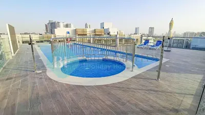 a swimming pool on the roof of a building at Bloomfileds Cozy Stu In Unistate Supreme Residence in Dubai