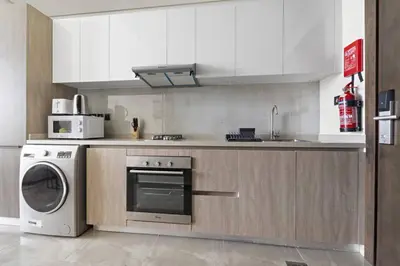 a kitchen with a washing machine and a microwave at Luxury Studio Apartments at Majestique Residence in Dubai
