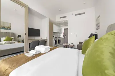 a bedroom with a large bed and a living room at Luxury Studio Apartments at Majestique Residence in Dubai
