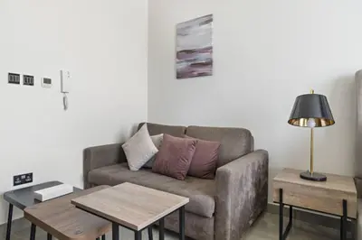 a living room with a couch and two tables at Luxury Studio Apartments at Majestique Residence in Dubai
