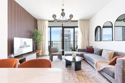 a living room with a couch and a tv at Stunning Home in Palace Residences on 41st Floor in Dubai