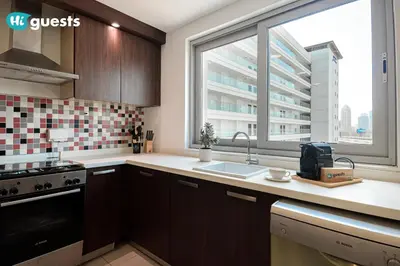 a kitchen with a sink and a large window at HiGuests - Premier Beachfront Stylish 2BR Apt and Maid Room in Dubai