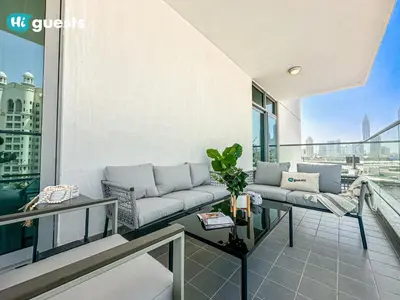 a living room with a couch on a balcony at HiGuests - Premier Beachfront Stylish 2BR Apt and Maid Room in Dubai