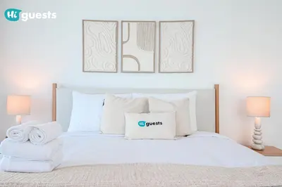 a bedroom with a white bed with two pillows at HiGuests - Premier Beachfront Stylish 2BR Apt and Maid Room in Dubai