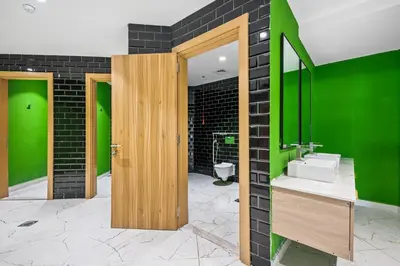 a bathroom with a sink and a green wall at Spacious Studio With Dubailand Charm in Dubai