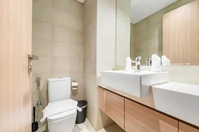 a bathroom with a white toilet and a sink at Cozy 1BR with Pool View & Balcony in Dubai