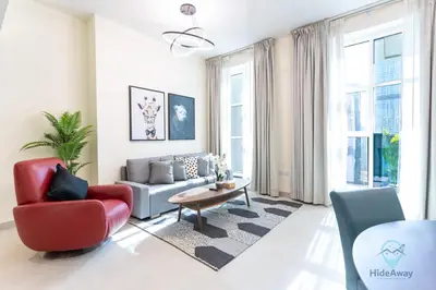 a living room with a red chair and a couch at 2BR Stunning Luxury Heart of Marina Near Beach in Dubai