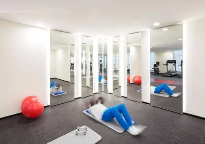 a woman laying on a pilates reformer in a gym at 2BR Stunning Luxury Heart of Marina Near Beach in Dubai