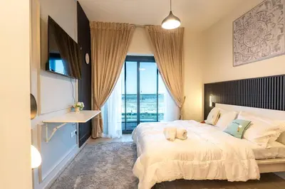 a bedroom with a large bed with a large window at Cozy studio in Azizi Riviera with beautiful views in Dubai