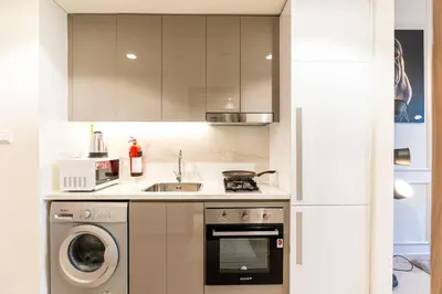 a kitchen with a sink and a washing machine at Cozy studio in Azizi Riviera with beautiful views in Dubai