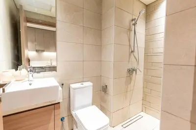 a bathroom with a toilet and a sink and a shower at Cozy studio in Azizi Riviera with beautiful views in Dubai