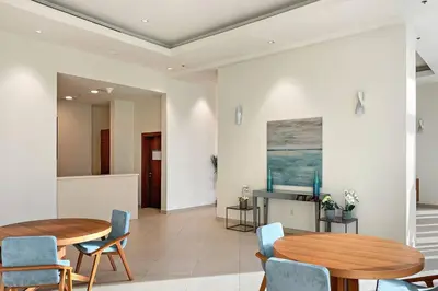 a dining room with two tables and blue chairs at Luxury 2BR Burj View with Pool Walk to Mall & Metro Dining Shopping in Dubai